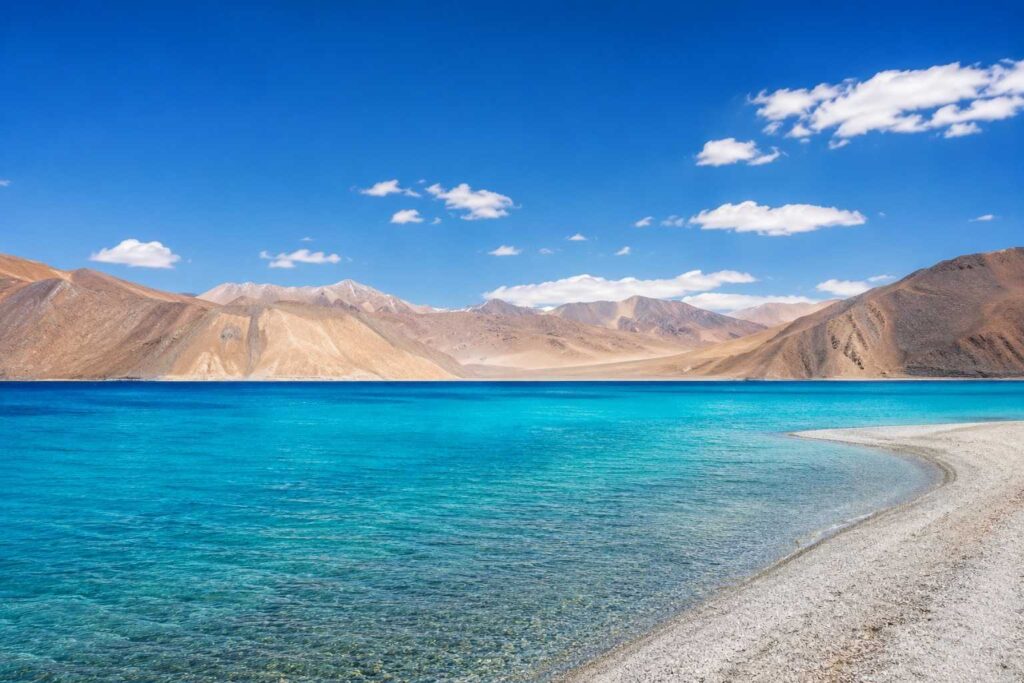Pangong Tso Lake with turquoise blue water surrounded by barren mountains in Leh Ladakh